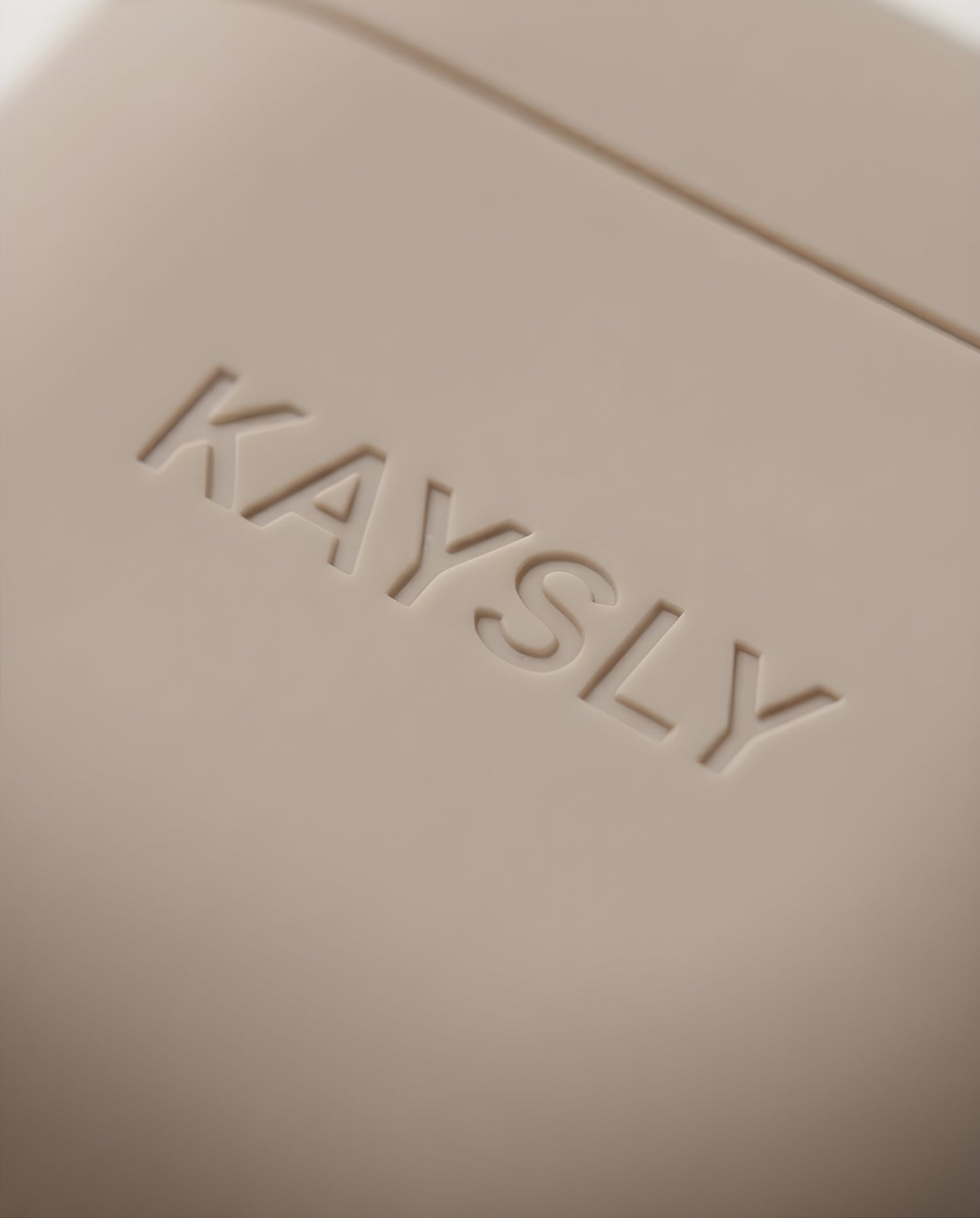 KAYSLY AirPod 4 Silikonskal Beige Trådlös Laddning - Close-up - Logo
