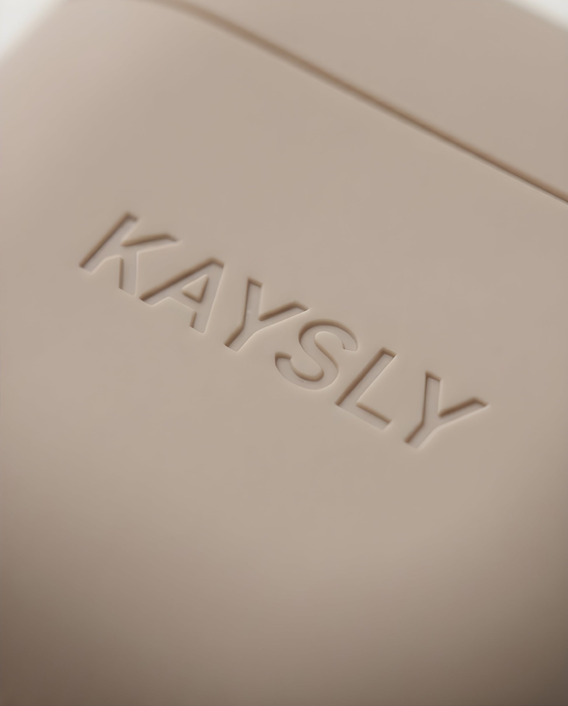 KAYSLY AirPod 4 Silikonskal Beige Trådlös Laddning - Close-up - Logo
