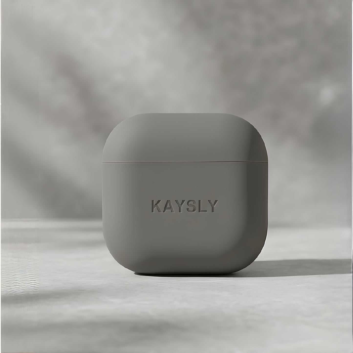 KAYSLY silikonskal för AirPods 4 i olivgrön/grå – framifrån på marmor
