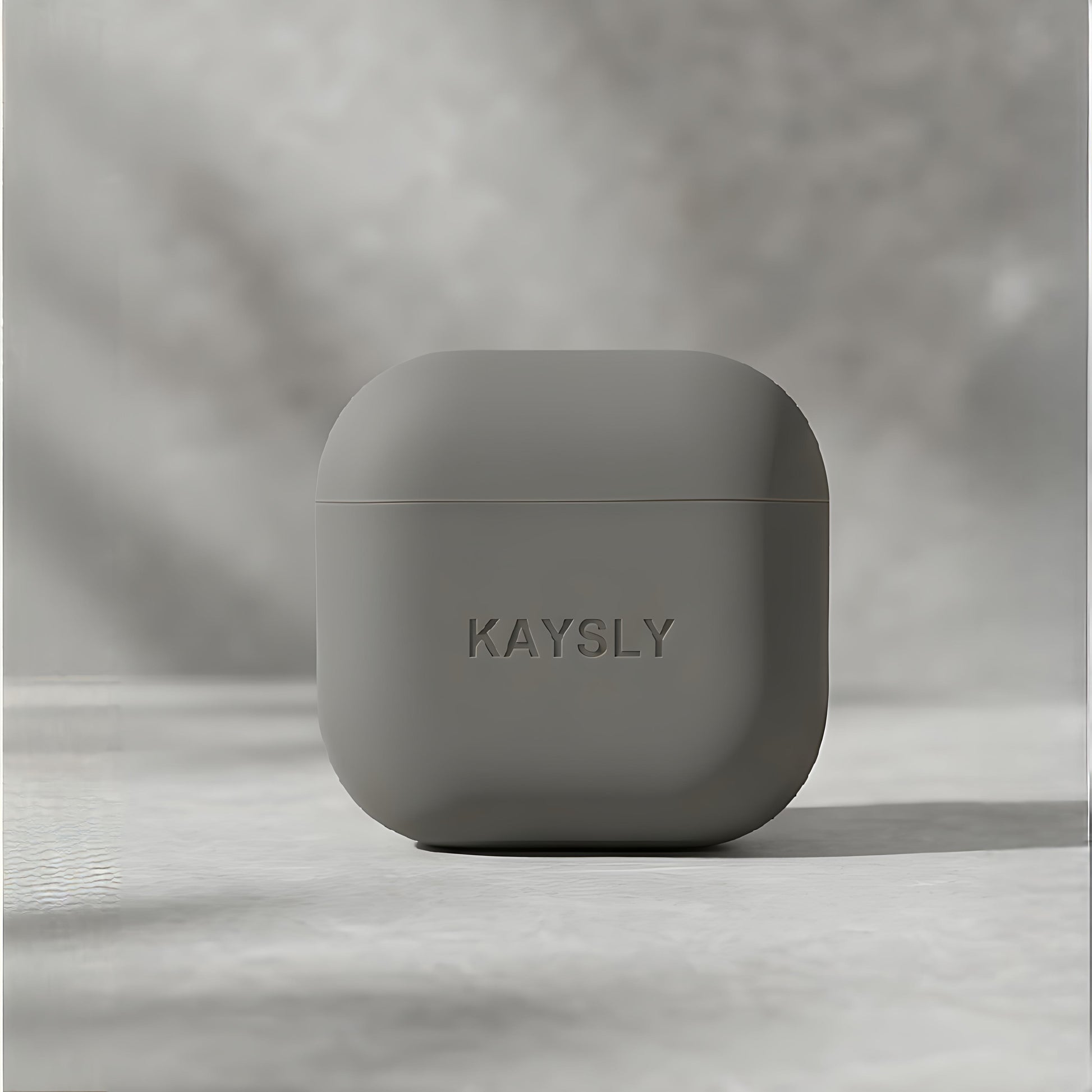 KAYSLY silikonskal för AirPods 4 i olivgrön/grå – framifrån på marmor